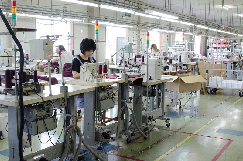 白鷺ニットの国内工場で縫製する女性